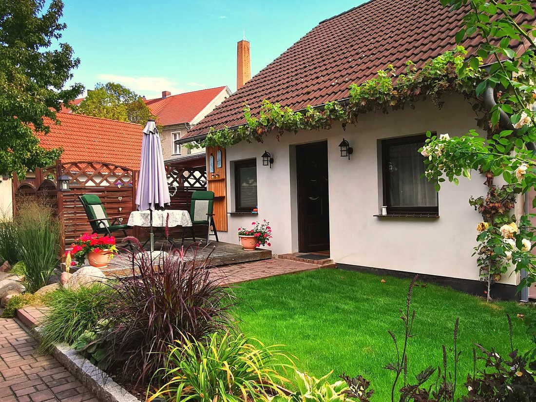 Das Ferienhaus Winkel-Stübchen mit rotem Ziegeldach, Rasen und Terrasse